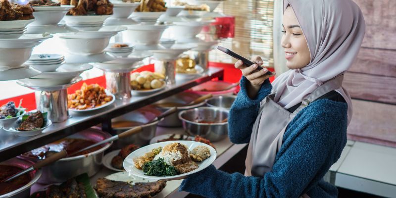 A Malaysian woman taking a photo of food