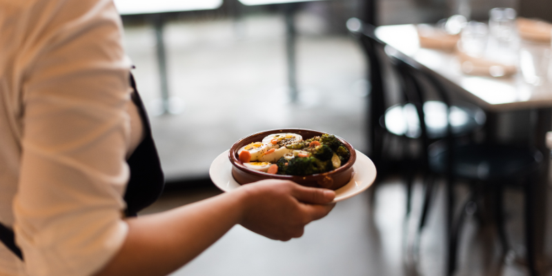 Staf restoran Malaysia menghidangkan makanan kepada pelanggan