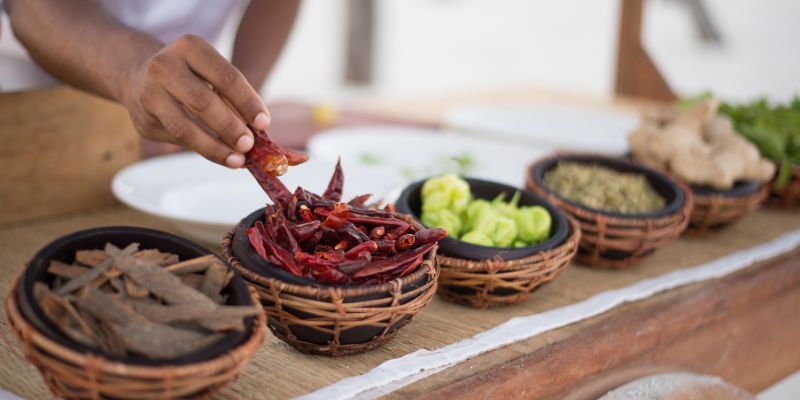 Seseorang sedang menyediakan makanan dengan pelbagai rempah