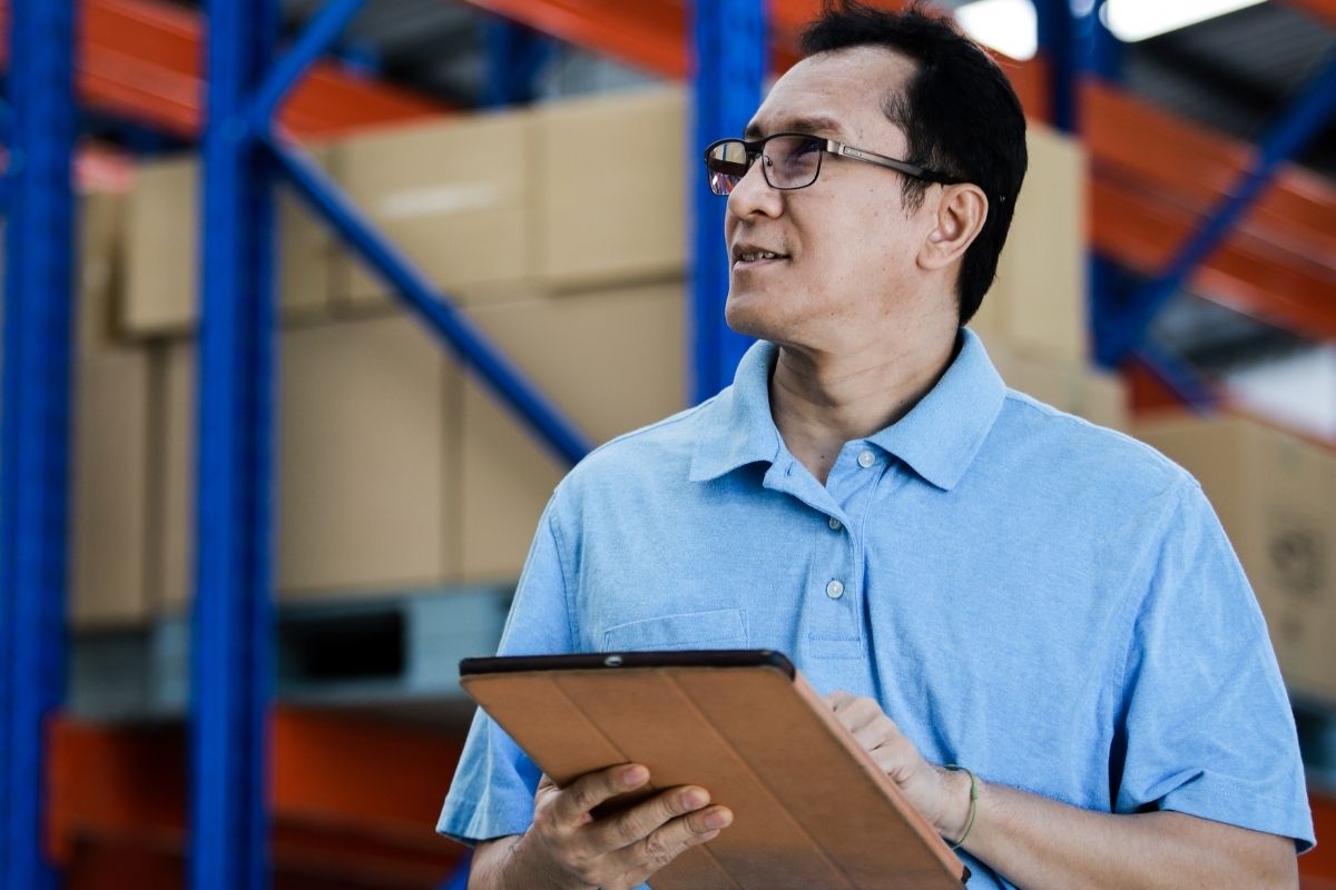 Malaysian business owner checking inventory at warehouse
