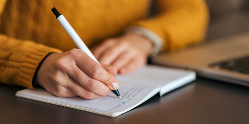 A Malaysian business owner writing in a notebook
