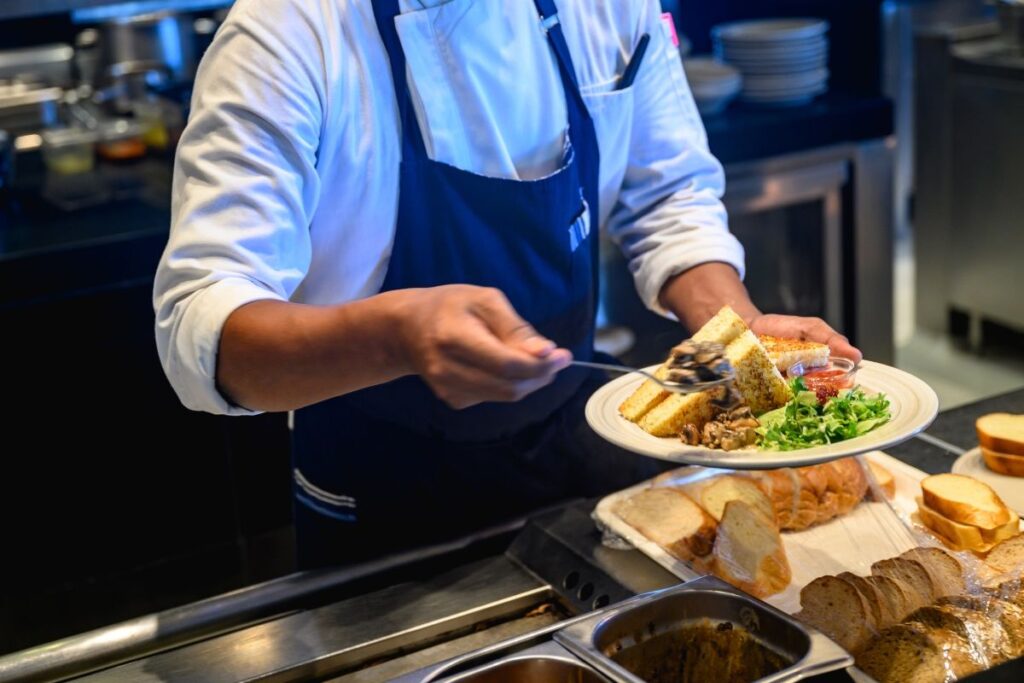A Malaysian F&B staff serving food to a customer
