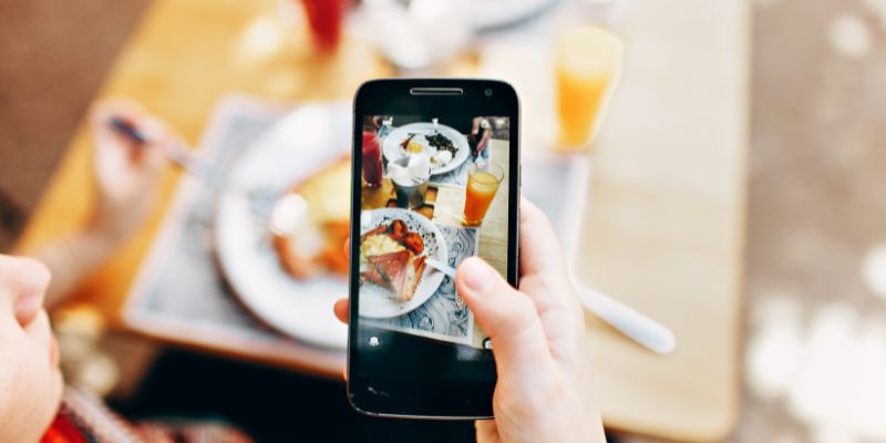 A Malaysian SME owner taking photo of food