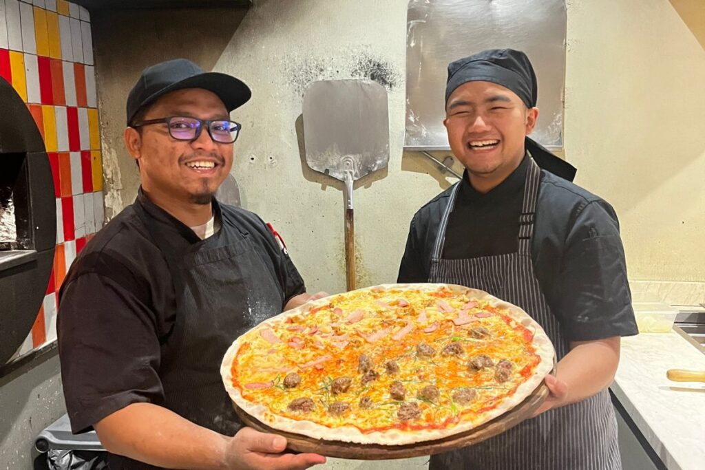 The Fino Piza Team with one of their signature pizzas